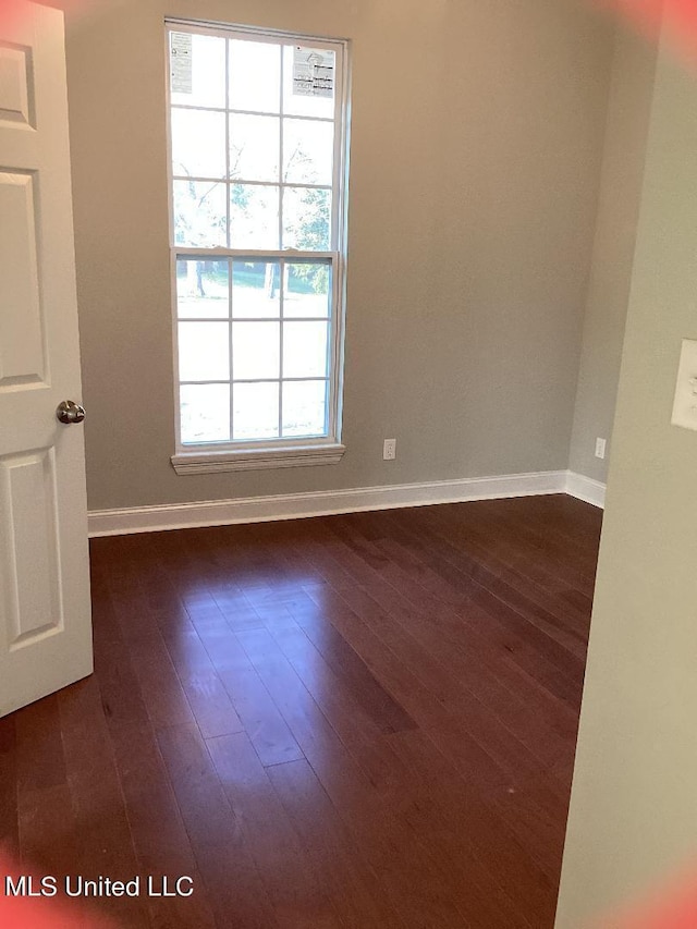 unfurnished room with dark hardwood / wood-style flooring