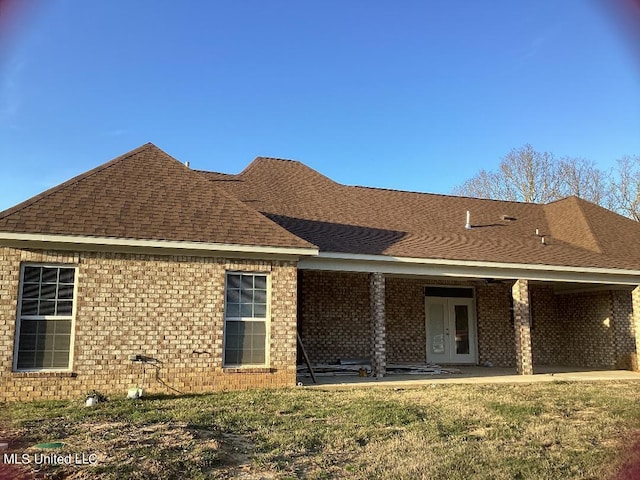 back of property featuring a patio and a yard