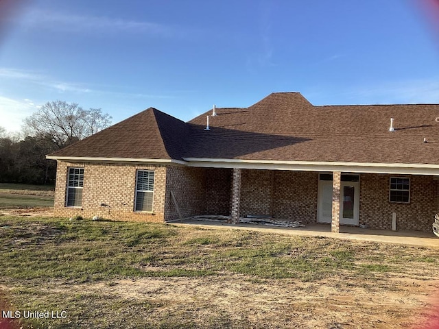 back of property featuring a patio and a lawn