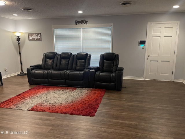 living room featuring recessed lighting, wood finished floors, baseboards, a textured ceiling, and crown molding