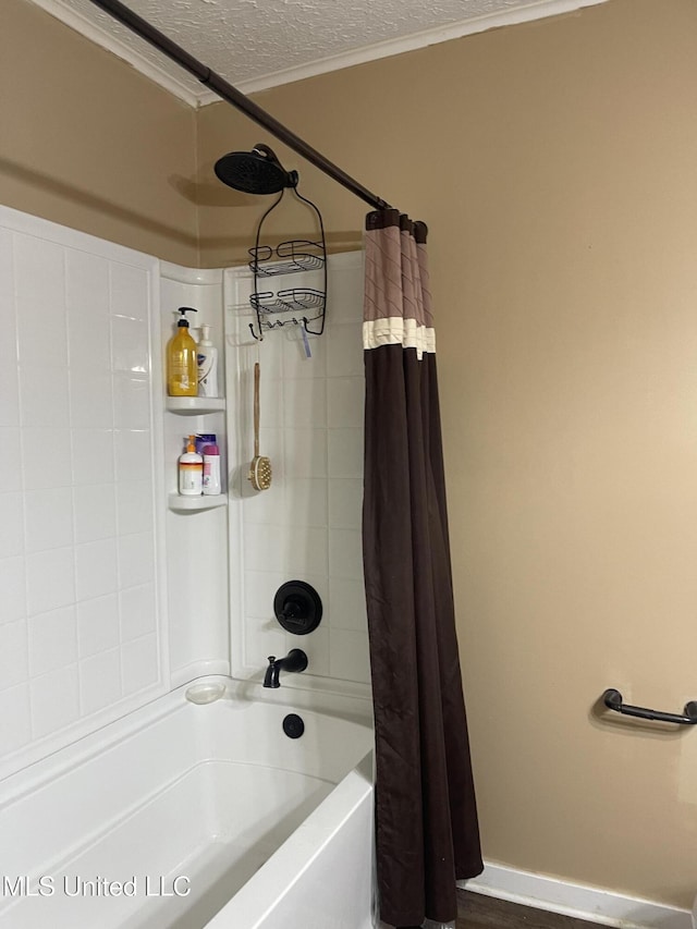 full bath with a textured ceiling, shower / bath combination with curtain, and ornamental molding