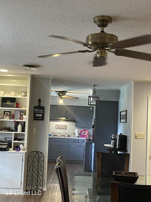 dining space with a textured ceiling, wood finished floors, and a ceiling fan