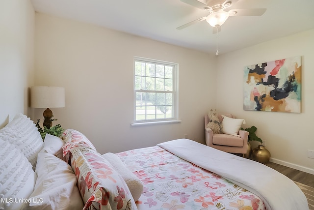 bedroom with wood finished floors, a ceiling fan, and baseboards