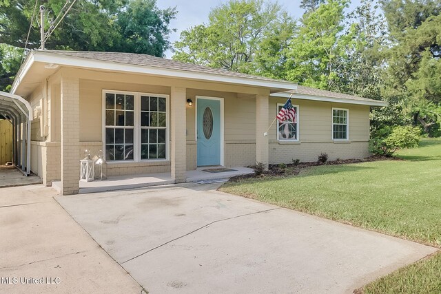 single story home featuring brick siding, a front yard, and concrete driveway