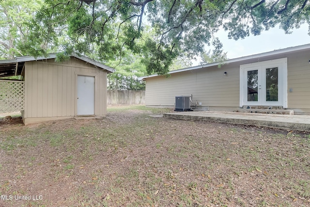 back of property featuring french doors, an outbuilding, cooling unit, fence, and a shed