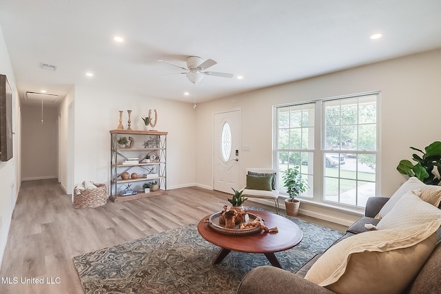 living area featuring light wood-type flooring, attic access, plenty of natural light, and ceiling fan