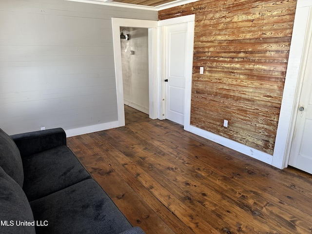 interior space with hardwood / wood-style floors, wood walls, and baseboards