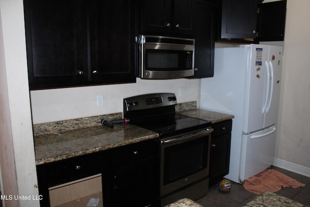 kitchen with appliances with stainless steel finishes, tile patterned floors, and light stone counters