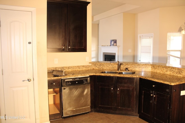 kitchen featuring sink, dishwasher, dark brown cabinets, light stone counters, and tile patterned floors