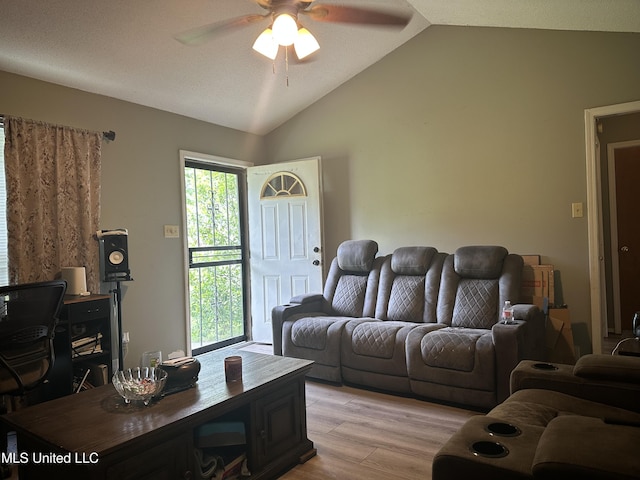 living area with a ceiling fan, light wood-type flooring, and vaulted ceiling