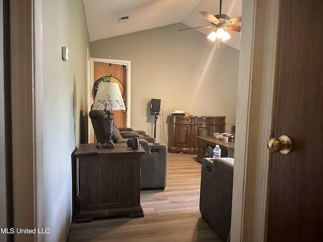 office with a ceiling fan, visible vents, light wood-type flooring, and vaulted ceiling