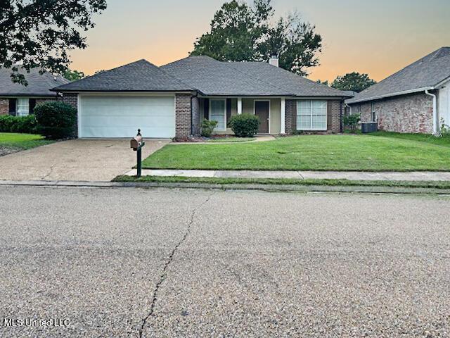 594 Acorn Ln, Brandon, MS 39047 - view of front of house featuring an attached garage, concrete driveway, a front yard, and brick siding