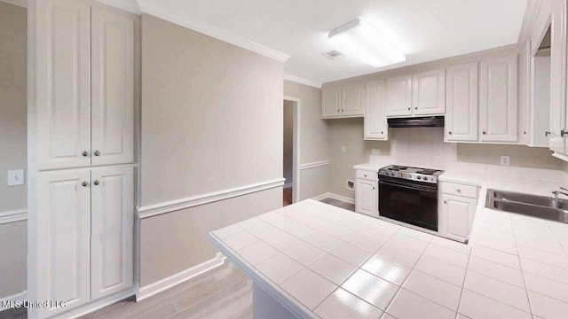 594 Acorn Ln, Brandon, MS 39047 - kitchen featuring white range with electric cooktop, exhaust hood, crown molding, a peninsula, and tile counters