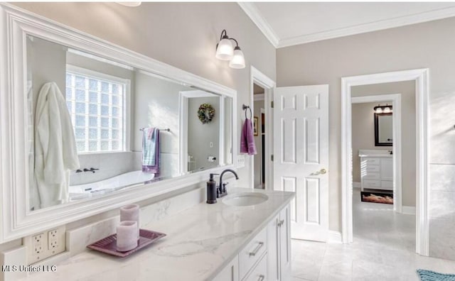 bathroom with baseboards, ornamental molding, a bath, and vanity