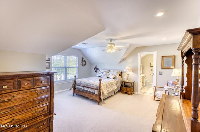 bedroom with lofted ceiling, light colored carpet, a ceiling fan, connected bathroom, and baseboards