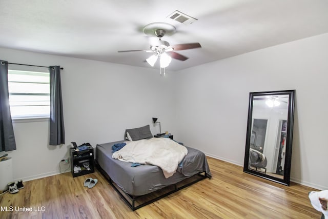 bedroom featuring visible vents, ceiling fan, light wood finished floors, and baseboards