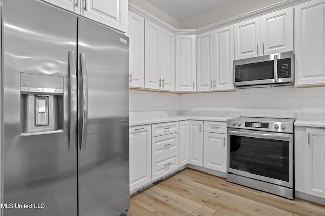 124 Court St, Bay Saint Louis, MS 39520 - kitchen with stainless steel appliances, light countertops, white cabinets, and light wood-style flooring