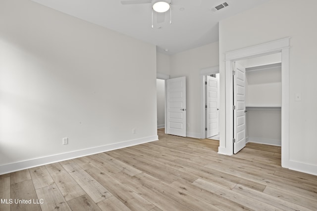 124 Court St, Bay Saint Louis, MS 39520 - unfurnished bedroom with light wood-type flooring, a spacious closet, ceiling fan, and a closet