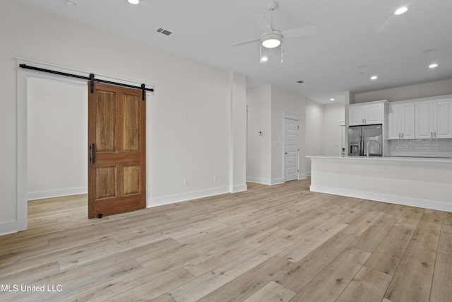124 Court St, Bay Saint Louis, MS 39520 - unfurnished living room featuring ceiling fan, a barn door, recessed lighting, and light wood-style flooring