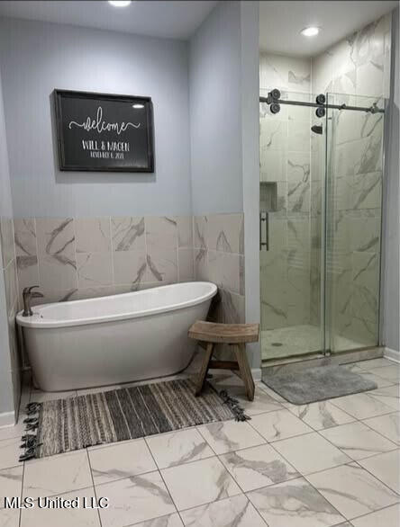 361 Cherry Bark Ln, Courtland, MS 38620 - full bath with marble finish flooring, a soaking tub, a stall shower, and tile walls