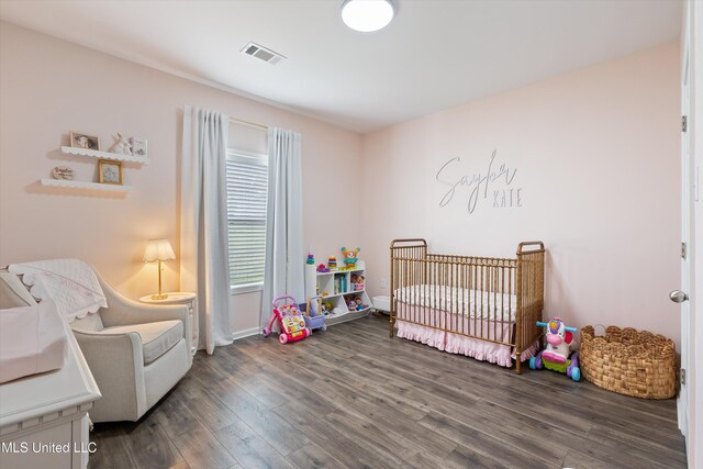 361 Cherry Bark Ln, Courtland, MS 38620 - bedroom with wood finished floors, a crib, and baseboards