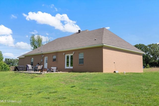 361 Cherry Bark Ln, Courtland, MS 38620 - rear view of house with a patio area, a lawn, brick siding, and a shingled roof