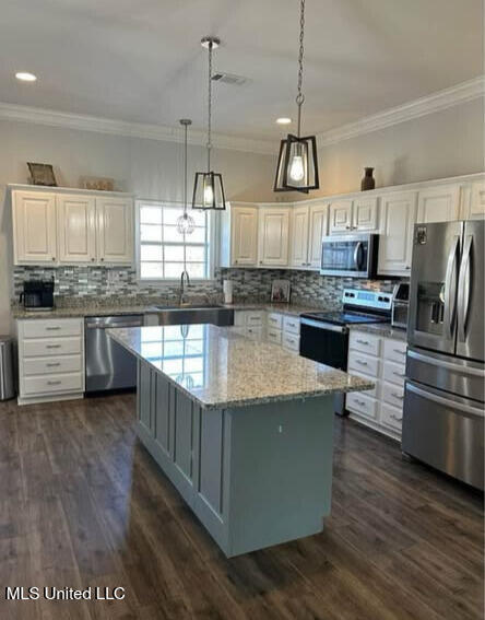 361 Cherry Bark Ln, Courtland, MS 38620 - kitchen featuring appliances with stainless steel finishes, ornamental molding, a kitchen island, backsplash, and a sink