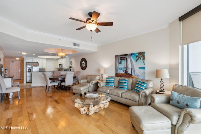 living room featuring crown molding, plenty of natural light, ceiling fan, and light wood-type flooring