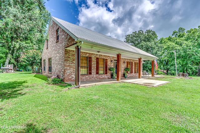 4661 Wildwood Rd, Benton, MS 39039 - rear view of property featuring brick siding, a lawn, and metal roof