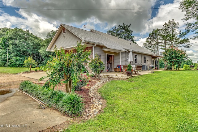4661 Wildwood Rd, Benton, MS 39039 - view of front facade featuring a patio, a front lawn, metal roof, and cooling unit