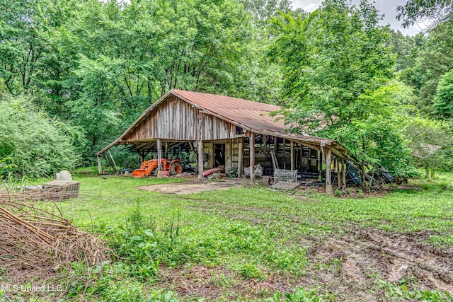 4661 Wildwood Rd, Benton, MS 39039 - view of front of property featuring metal roof, a front yard, a pole building, and a wooded view