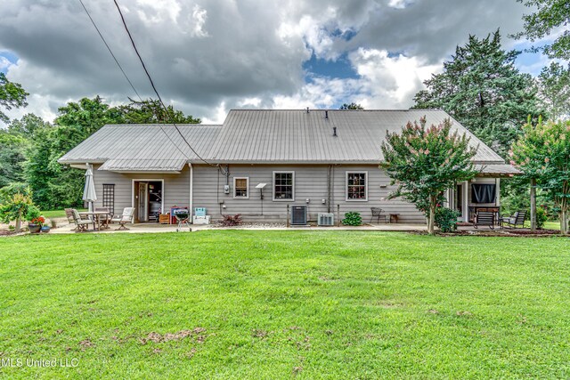 4661 Wildwood Rd, Benton, MS 39039 - rear view of house featuring a patio area, a lawn, central AC, and metal roof