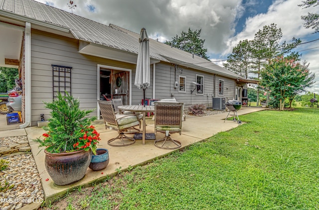 4661 Wildwood Rd, Benton, MS 39039 - rear view of property with metal roof, a patio area, a lawn, and cooling unit