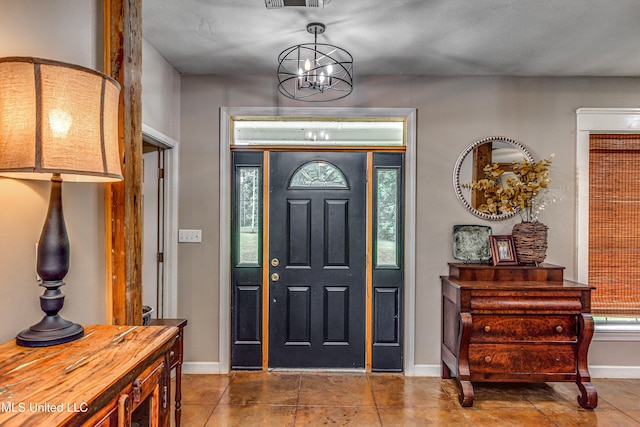 4661 Wildwood Rd, Benton, MS 39039 - entryway with baseboards, tile patterned flooring, and a chandelier