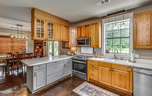 4661 Wildwood Rd, Benton, MS 39039 - kitchen with stainless steel appliances, a sink, a peninsula, glass insert cabinets, and light countertops