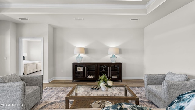 living room featuring hardwood / wood-style flooring and crown molding