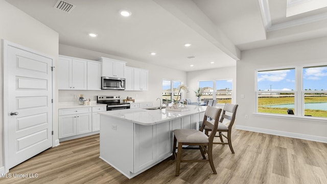 kitchen with white cabinetry, sink, a kitchen island with sink, stainless steel appliances, and light hardwood / wood-style flooring