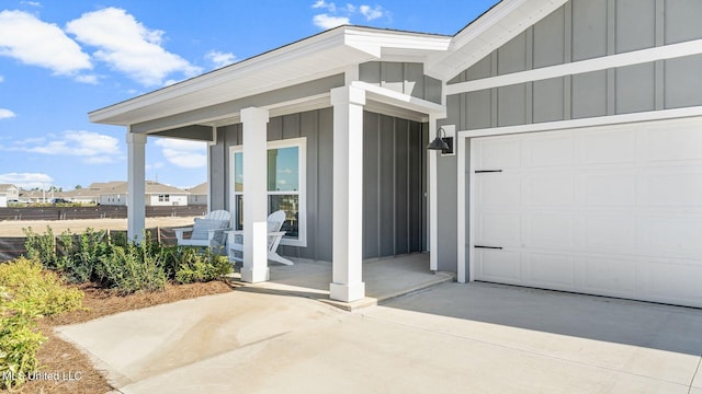 entrance to property featuring a porch and a garage