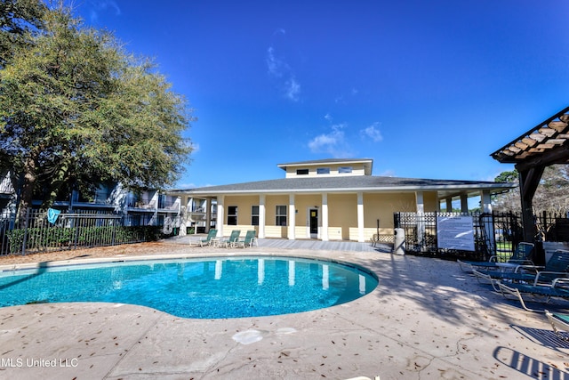 community pool with a patio and fence