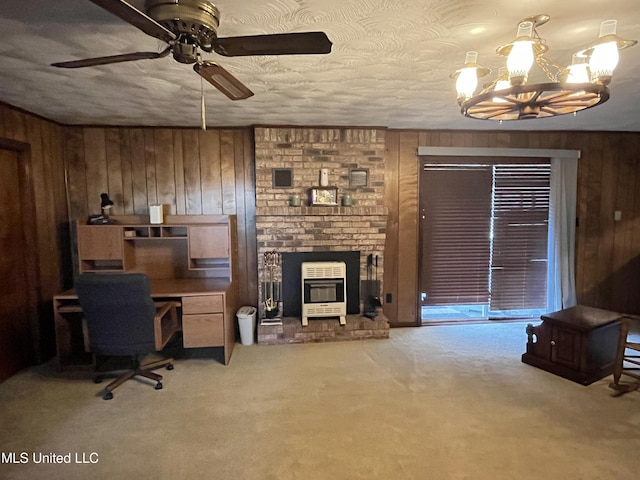 carpeted office featuring a textured ceiling, ceiling fan with notable chandelier, wood walls, and a fireplace