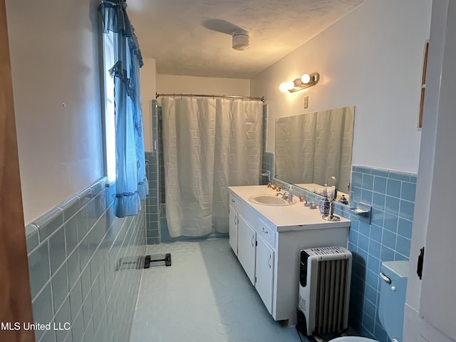 bathroom with curtained shower, vanity, and tile walls