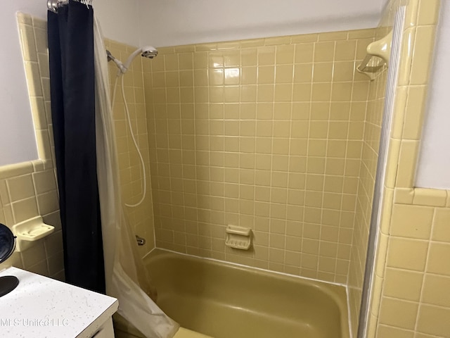 bathroom with shower / bath combo and tile walls