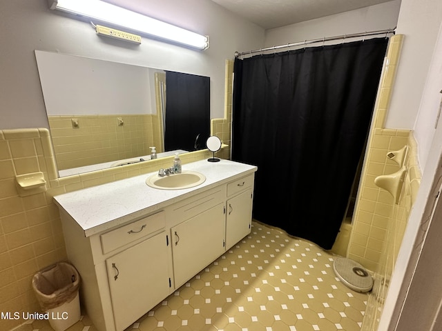 bathroom with vanity and tile walls