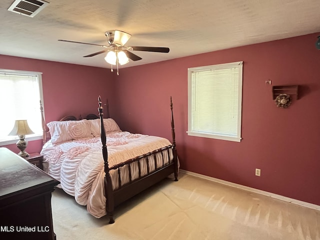 carpeted bedroom featuring ceiling fan and a textured ceiling