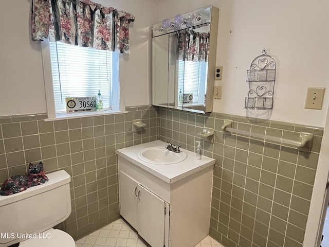 bathroom with tile patterned floors, plenty of natural light, and tile walls