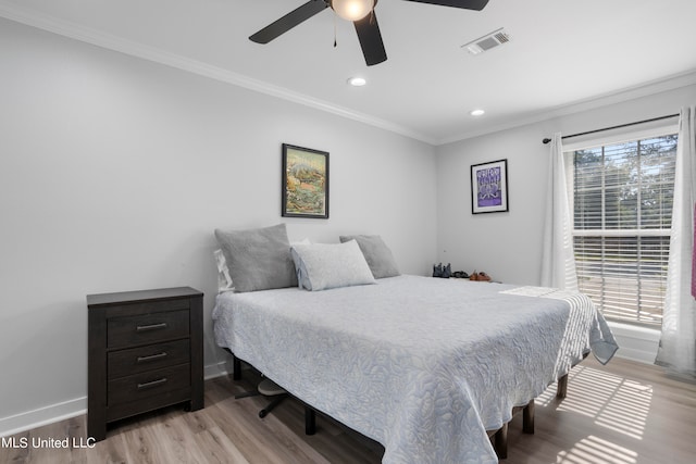 bedroom featuring ornamental molding, light hardwood / wood-style floors, and ceiling fan