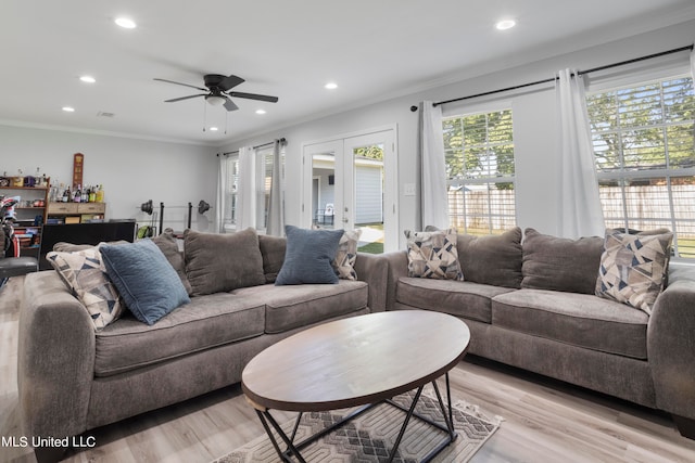 living room featuring french doors, ceiling fan, ornamental molding, and light wood-type flooring