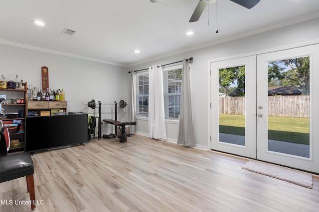 interior space with french doors, ornamental molding, light wood-type flooring, and ceiling fan