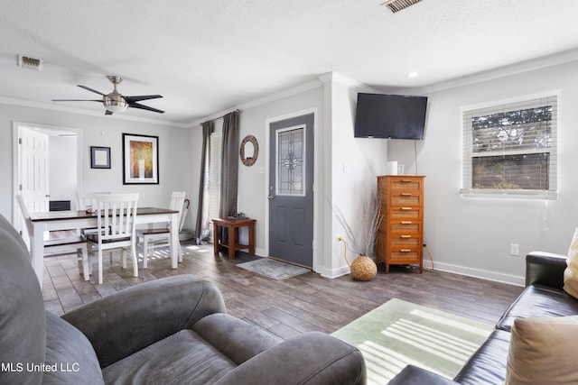 living room with ornamental molding, ceiling fan, a textured ceiling, and dark hardwood / wood-style flooring