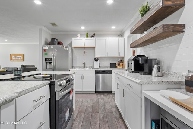 kitchen with appliances with stainless steel finishes, backsplash, white cabinets, crown molding, and dark hardwood / wood-style floors